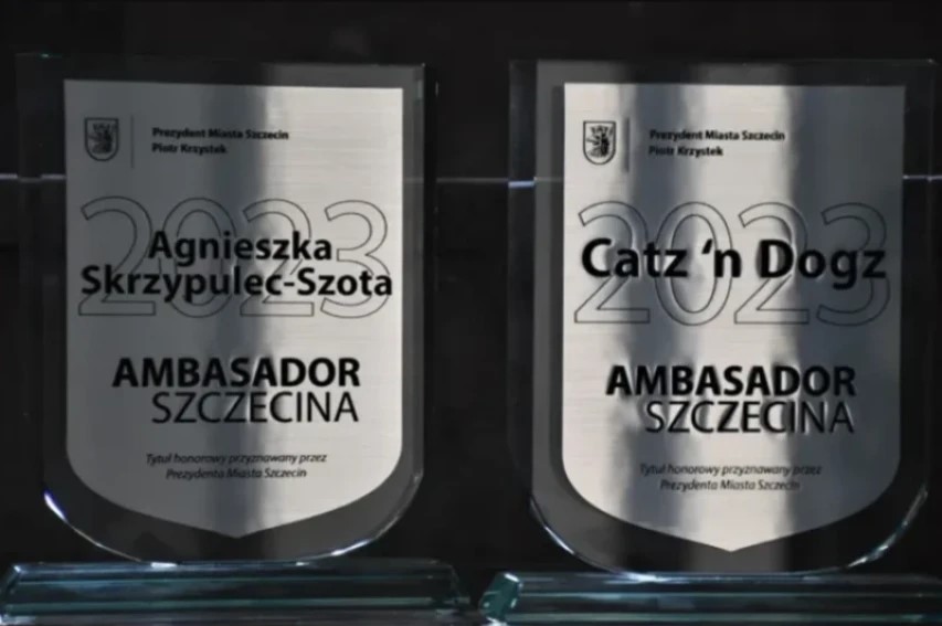 Zdjęcie przedstawia dwie statuetki z poprzedniego roku, a na tabliczka imię zeszłorocznej laureatki Agnieszki Skrzypulec- Szota oraz organizacji Catz`n Dogz